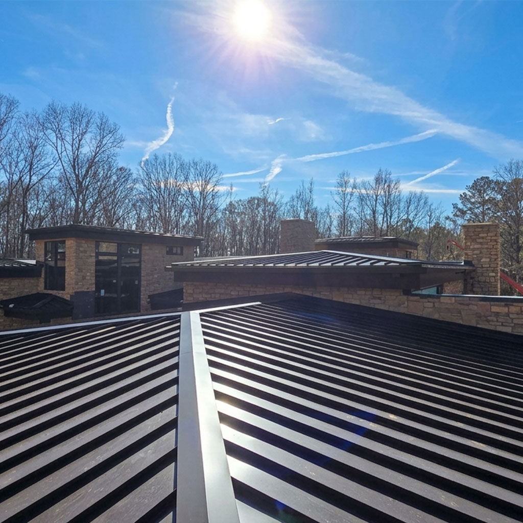 Navy standing seam metal roof on a modern Texas ranch home at sunset